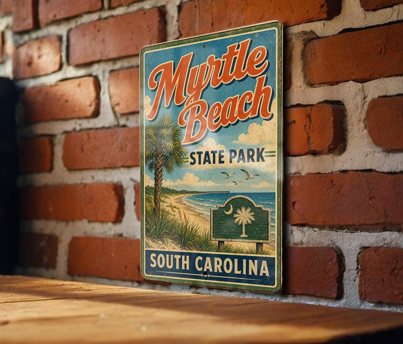 A vintage-style metal sign for Myrtle Beach State Park in South Carolina, featuring a palm tree and beach scene, is displayed on a brick wall.