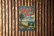 A vintage-style metal sign for Myrtle Beach State Park in South Carolina, featuring a palm tree and beach scene.