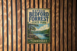 A vintage metal sign for Nathan Bedford Forrest State Park in Tennessee, featuring a scenic landscape with a lake and mountains.