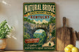A vintage-style sign for Natural Bridge State Resort Park in Kentucky, featuring a scenic image of the arch and the surrounding landscape.