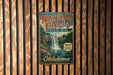 A vintage-style metal sign for Natural Falls State Park in Oklahoma, featuring a waterfall and lush greenery.