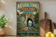 A vintage-style sign for the Natural Tunnel State Park in Virginia, featuring a scenic image of a tunnel surrounded by lush greenery and mountains.
