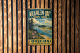 A vintage-style metal sign for Nehalem Bay State Park in Oregon, featuring a scenic landscape with mountains, trees, and a river.