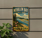 A vintage-style metal sign for Nehalem Bay State Park in Oregon, featuring a scenic landscape with a river, mountains, and pine trees.