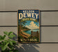 A vintage-style metal sign for Nelson Dewey State Park in Wisconsin, featuring a scenic landscape with pine trees, a lake, and a beach.