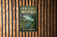 A vintage-style metal sign for New Glarus Woods State Park in Wisconsin, featuring a scenic illustration of a river and forest landscape.