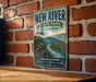 A vintage-style metal sign for New River State Park in North Carolina, featuring a scenic illustration of a river and mountains.