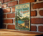 A vintage-style metal sign for Nickerson State Park in Massachusetts, featuring a scenic landscape with a lake, trees, and mountains.