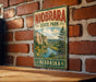 A vintage-style metal sign for Niobrara State Park in Nebraska, featuring a scenic landscape with a river, mountains, and wildflowers.