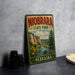 A vintage-style metal sign for Niobrara State Park in Nebraska, featuring a scenic landscape with a river, mountains, and wildflowers.