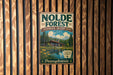 A vintage-style metal sign for the Nolde Forest Environmental Education Center in Pennsylvania, featuring a scenic image of a cabin surrounded by nature.