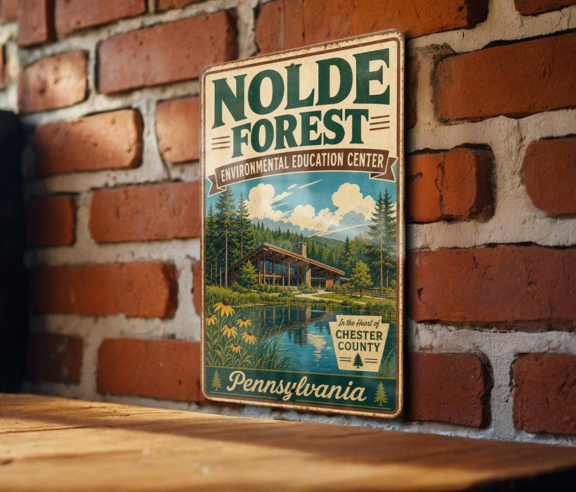 A vintage-style metal sign for the Nolde Forest Environmental Education Center in Pennsylvania, featuring a scenic illustration of a cabin surrounded by nature.