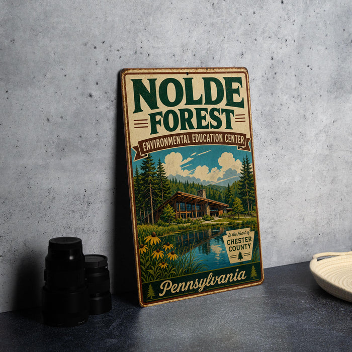 A vintage-style metal sign for the Nolde Forest Environmental Education Center in Pennsylvania, featuring a cabin surrounded by trees and a lake.