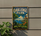 A vintage-style metal sign for Oakledge Park in Vermont, featuring a scenic lake view with a building and a sailboat.