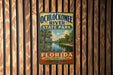 A vintage-style metal sign for Ochlockonee River State Park in Florida, featuring a tropical landscape with palm trees and a river.