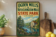 A vintage-style sign for Ogden Mills & Ruth Livingston Mills State Park in New York, featuring a scenic illustration of a river and forest.
