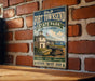 A vintage-style metal sign for Fort Towsend State Park in Washington, featuring an illustration of a historic building and cannon, mounted on a brick wall.