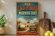A vintage-style sign for Old Las Vegas Mormon Fort, Nevada, featuring a wagon and a desert landscape, is displayed on a shelf next to a wooden cutting board and some lemons.