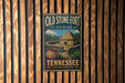 A vintage-style metal sign for Old Stone Fort State Archaeological Park in Tennessee, featuring a wooden fence and a depiction of a hut with a thatched roof.