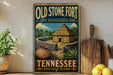 A vintage-style sign for Old Stone Fort State Archaeological Park in Tennessee, featuring a depiction of a thatched-roof hut and a stone wall, along with a wooden paddle and a potted plant.