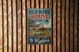 A vintage-style metal sign for Old Wade House State Park in Wisconsin, featuring an illustration of a house and a sign with the text "Old Wade House State Park" and "Wisconsin".