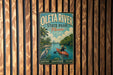 A vintage-style metal sign for Oleta River State Park in Florida, featuring a person kayaking and surrounded by palm trees.