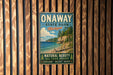 A vintage-style metal sign for Onaway State Park in Michigan, featuring a scenic beach landscape with pine trees and a lake.