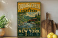 A vintage-style sign for Quagga Creek State Park, featuring a scenic illustration of a covered bridge and a river flowing through a forested landscape.