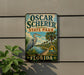A vintage-style sign for Oscar Scherer State Park in Florida, featuring a large blue heron and palm trees, mounted on a wall.