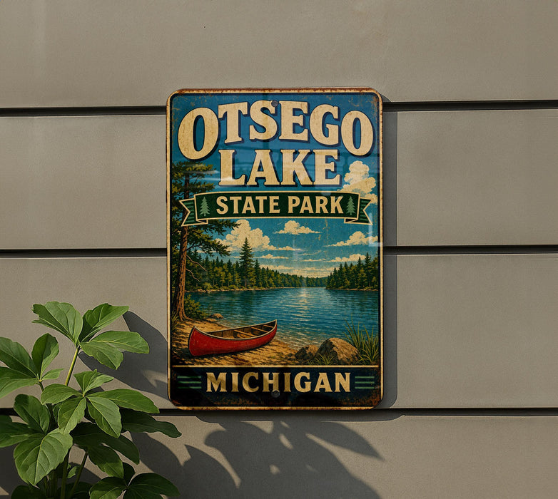 A metal sign with the text "OTSEGO LAKE STATE PARK MICHIGAN" and an illustration of a red canoe on a lake, mounted on a wall.