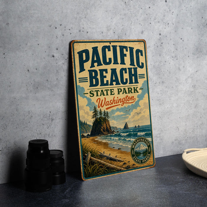 A vintage-style sign for Pacific Beach State Park in Washington, featuring a scenic beach landscape with mountains in the background.