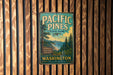 A vintage metal sign for Pacific Pines State Park in Washington, featuring a scenic illustration of the park's natural surroundings.