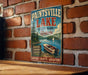 A vintage-style sign for Paintsville Lake, Kentucky, featuring a scenic image of a boat on the lake and a forested area.