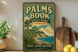 A vintage-style sign for Palm Book State Park in Michigan, featuring a tropical beach scene with palm trees and a body of water.