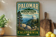 A vintage-style sign for Palomar Mountain State Park in California, featuring a scenic landscape with mountains, trees, and a dome-shaped building.