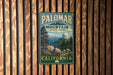 A vintage metal sign for Palomar Mountain State Park in California, featuring a scenic illustration of the park's landscape.