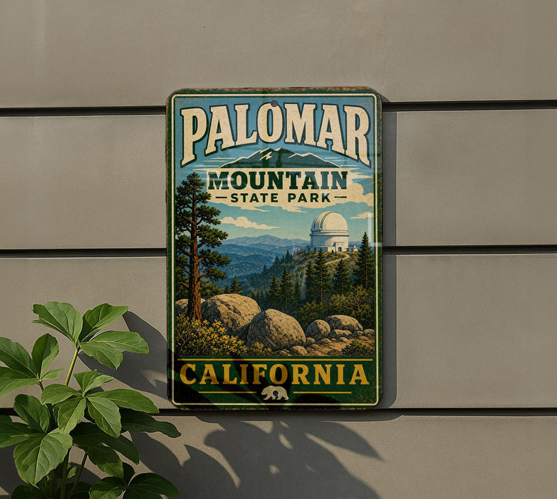 A vintage metal sign for Palomar Mountain State Park in California, featuring a scenic landscape with mountains, trees, and a dome-shaped building.