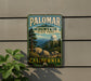 A vintage metal sign for Palomar Mountain State Park in California, featuring a scenic landscape with mountains, trees, and a dome-shaped building.