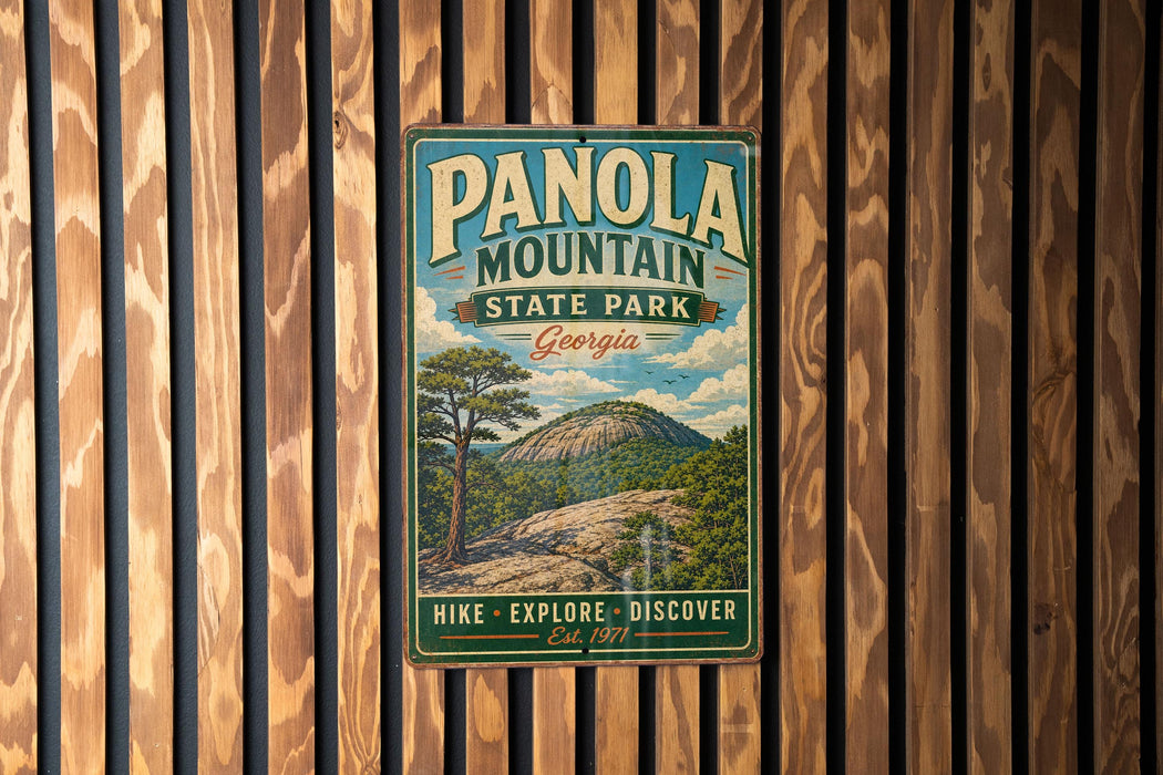 A vintage metal sign for Panola Mountain State Park in Georgia, featuring a scenic illustration of the mountain landscape.