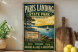 A vintage-style metal sign for Paris Landing State Park in Tennessee, featuring a scenic image of a lake with a sailboat, surrounded by trees and mountains.