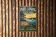 A vintage-style metal sign for Paris Landing State Park in Tennessee, featuring a scenic image of a lake and a sailboat.