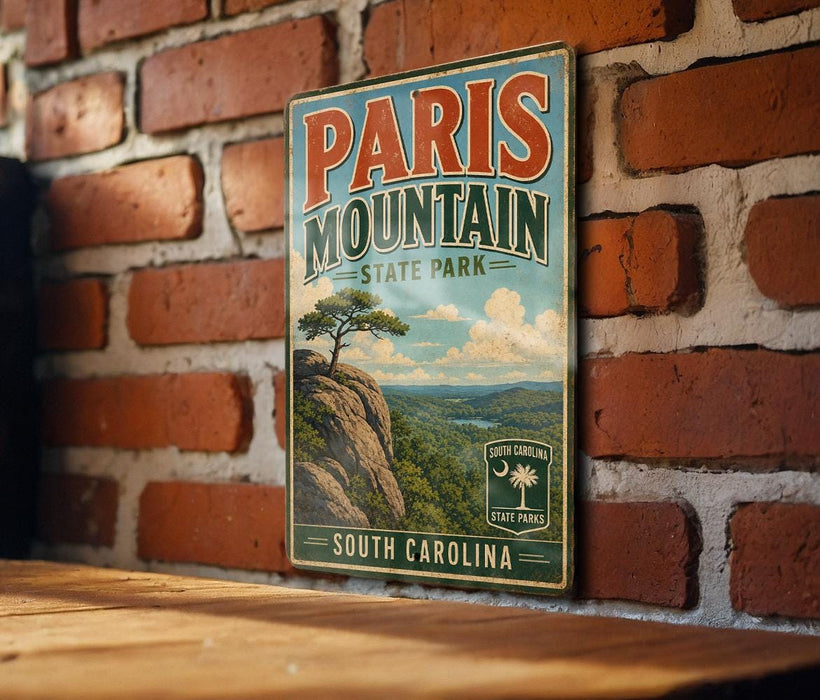 A vintage-style metal sign for Paris Mountain State Park in South Carolina is displayed on a brick wall.