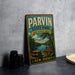 A vintage-style metal sign for Parvin State Park, featuring a scenic image of a picnic area and a river, is displayed on a gray countertop next to a stack of black camera lenses.