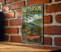 A vintage-style metal sign for Pennsylvania State Park, featuring a scenic landscape with pine trees and a lake, mounted on a brick wall.
