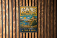 A vintage metal sign for the Pawnee State Recreation Area in Nebraska, featuring a scenic landscape with a mountain, lake, and sunflowers.