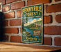 A vintage-style sign for Pennyle Forest State Resort Park, featuring a scenic image of a lake and a cabin surrounded by trees.