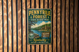A vintage-style metal sign for the Pennyville Forest State Resort Park in Kentucky, featuring a scenic image of the park and a cabin.