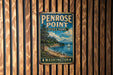 A vintage metal sign for Penrose Point State Park in Washington, featuring a scenic landscape with a mountain, trees, and a lake.