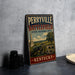A vintage metal sign for Perryville Battlefield, a state historic site in Kentucky, featuring an illustration of a cannon and a landscape with a monument.