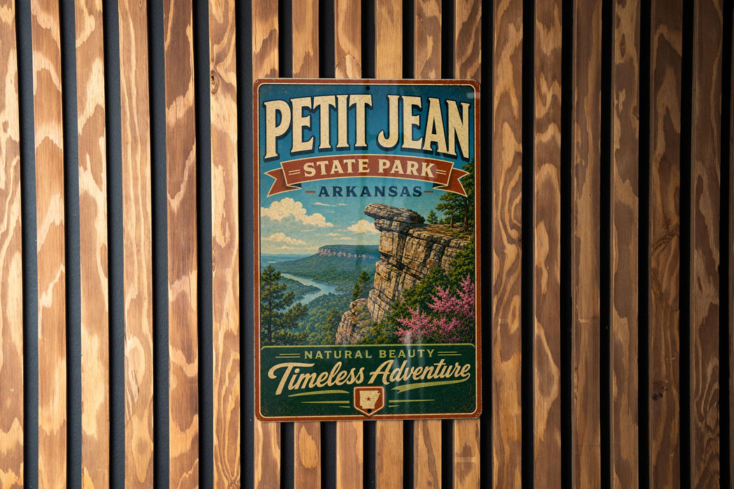 A vintage-style metal sign for Petit Jean State Park in Arkansas, featuring a scenic landscape with a cliff and river.